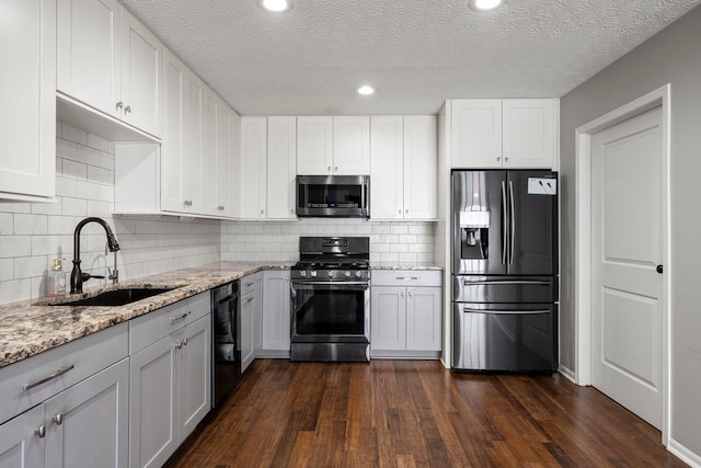 6709 Axtel Dr Unit 5A, Canal Winchester, OH 43110 - kitchen featuring a sink, dark wood-style flooring, stainless steel appliances, and light stone counters