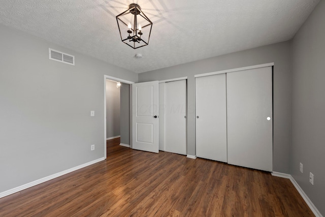6709 Axtel Dr Unit 5A, Canal Winchester, OH 43110 - unfurnished bedroom with baseboards, multiple closets, visible vents, and wood finished floors