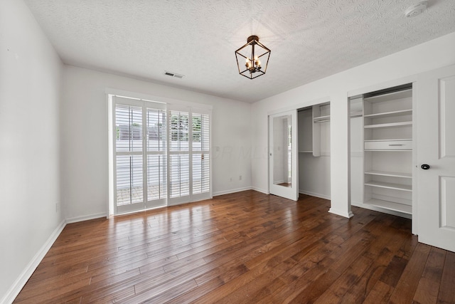 6709 Axtel Dr Unit 5A, Canal Winchester, OH 43110 - unfurnished bedroom featuring two closets, a textured ceiling, visible vents, and wood finished floors