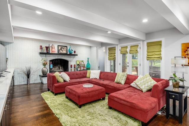 living room featuring a fireplace with raised hearth, beamed ceiling, dark wood finished floors, and recessed lighting