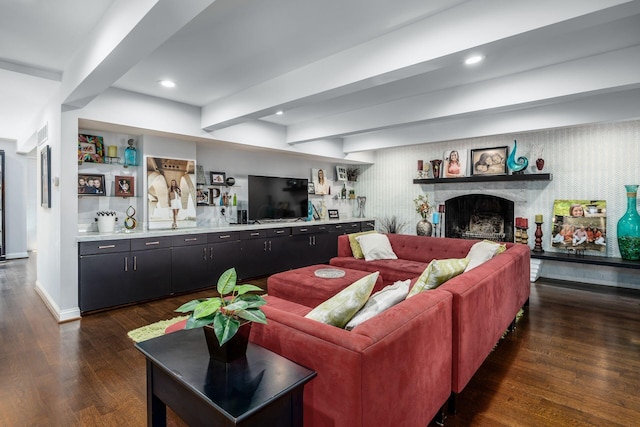 living area with visible vents, wood finished floors, a fireplace, indoor wet bar, and baseboards
