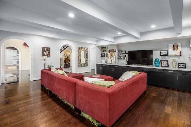 living room with arched walkways, dark wood finished floors, baseboards, beamed ceiling, and recessed lighting