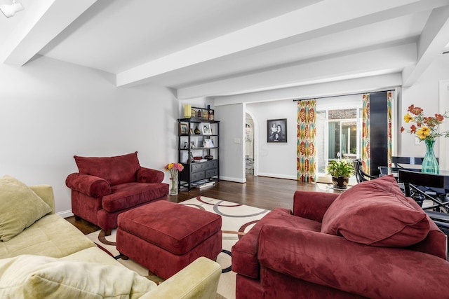 living room with arched walkways, baseboards, wood finished floors, and beam ceiling