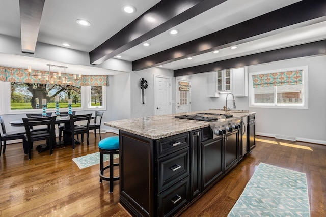 kitchen with dark cabinetry, white cabinetry, stainless steel gas cooktop, and recessed lighting