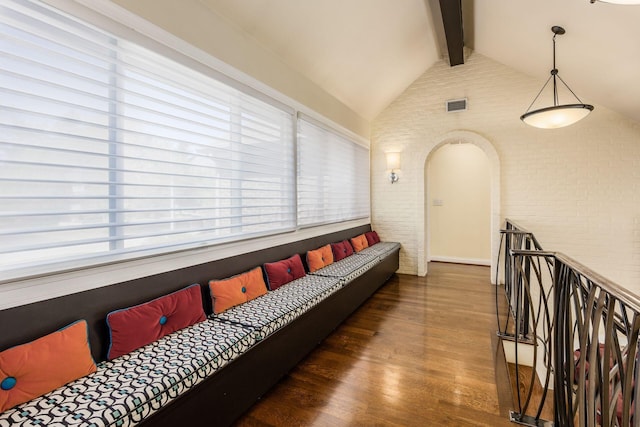 unfurnished living room with visible vents, lofted ceiling with beams, wood finished floors, and a healthy amount of sunlight