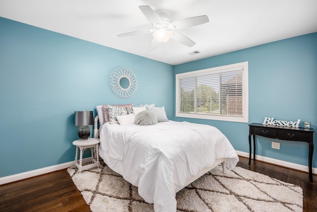 bedroom featuring visible vents, a ceiling fan, baseboards, and wood finished floors