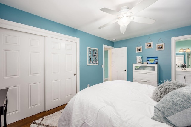 bedroom with a sink, a ceiling fan, ensuite bathroom, dark wood-style floors, and a closet