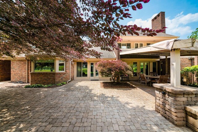 4070 Lyon Dr, Upper Arlington, OH 43220 - back of house featuring brick siding, a patio, a chimney, and french doors
