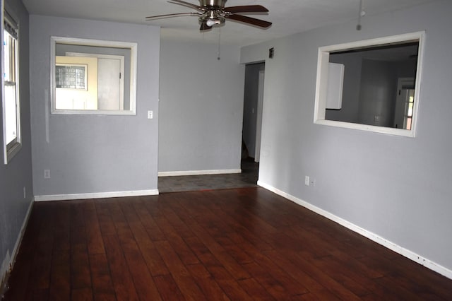 unfurnished room with wood finished floors, a ceiling fan, and baseboards