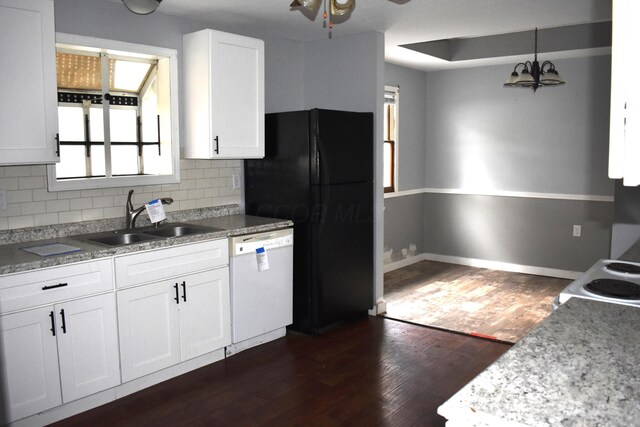 kitchen with white dishwasher, a sink, decorative backsplash, white cabinetry, and freestanding refrigerator