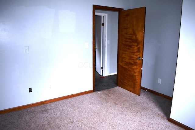 empty room featuring carpet flooring and baseboards
