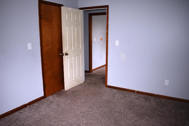 spare room featuring carpet and baseboards