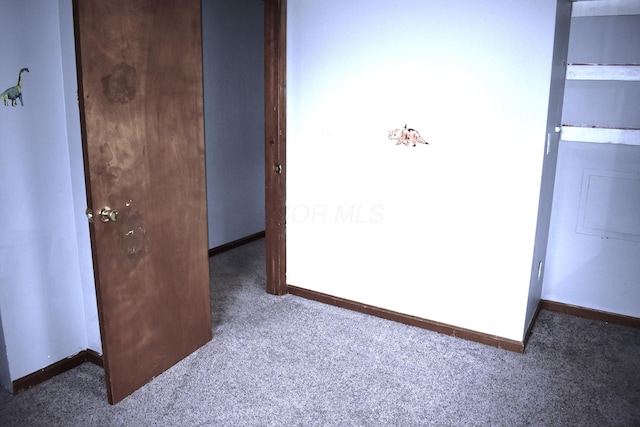 unfurnished bedroom featuring carpet, a closet, and baseboards