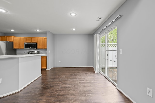 kitchen with appliances with stainless steel finishes, recessed lighting, dark wood-style flooring, light countertops, and baseboards