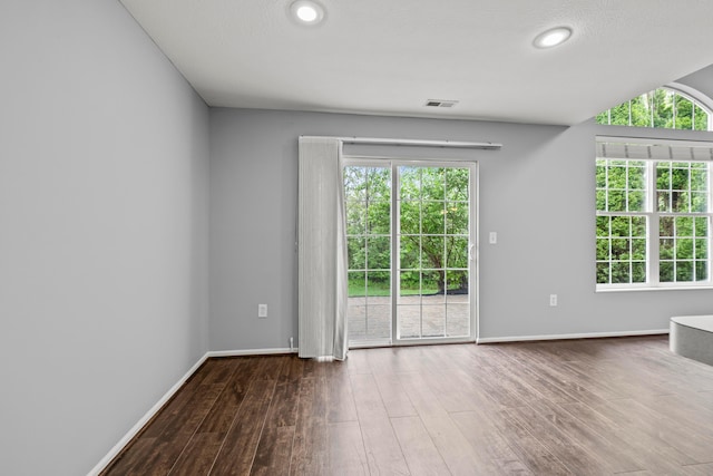 spare room featuring wood finished floors, baseboards, and recessed lighting