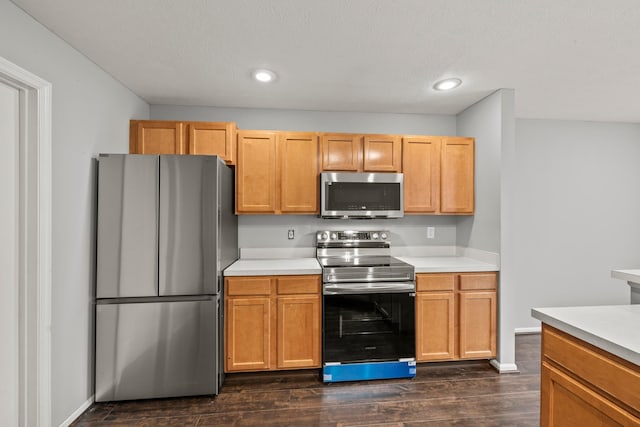 kitchen featuring stainless steel appliances, dark wood-style flooring, light countertops, and recessed lighting