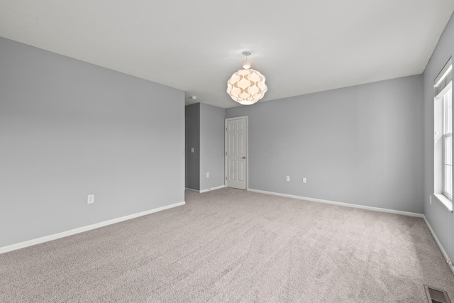 carpeted empty room with baseboards