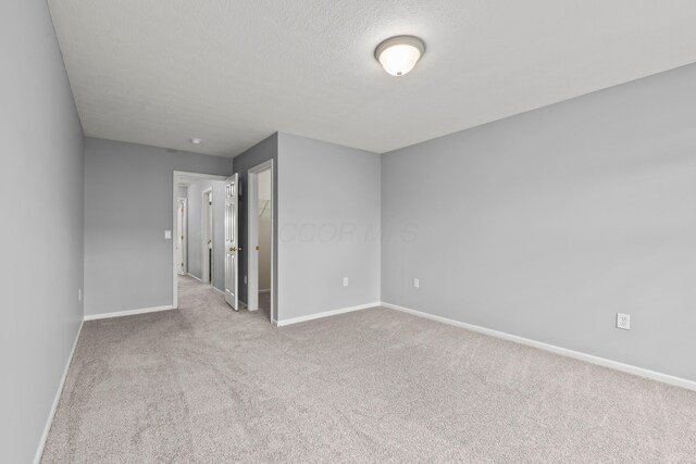 unfurnished room with baseboards and carpet
