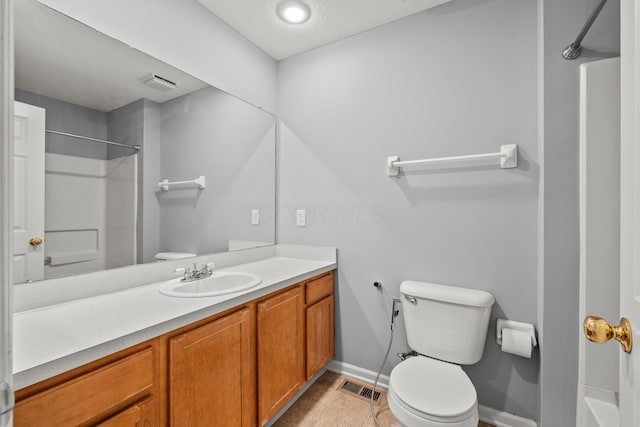 bathroom with toilet, baseboards, vanity, and tile patterned flooring
