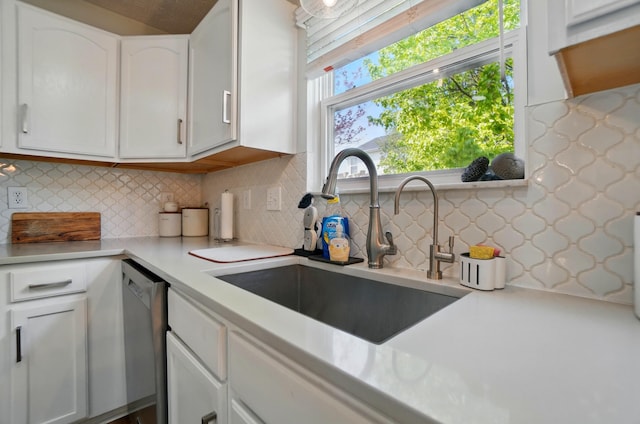 kitchen with a sink, white cabinets, and light countertops