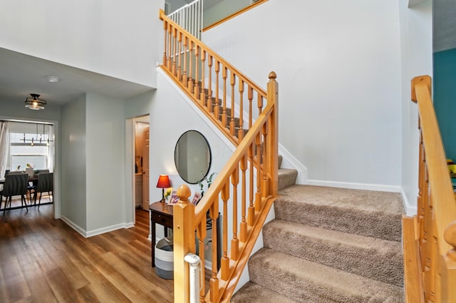 staircase with baseboards and wood finished floors
