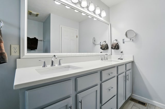 bathroom featuring a sink, double vanity, and visible vents