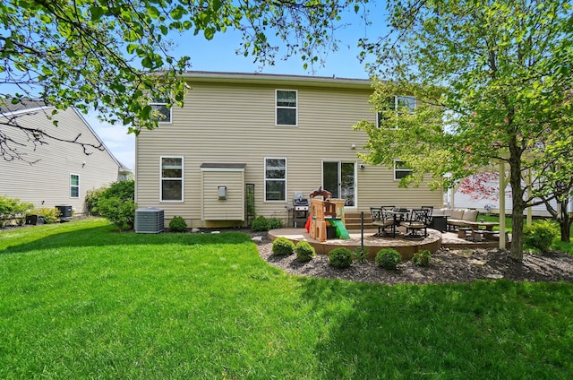 rear view of property with a lawn, an outdoor living space, a patio area, and central AC