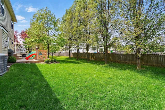 view of yard with fence, a playground, and cooling unit