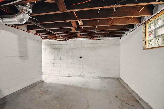 unfinished basement featuring concrete block wall