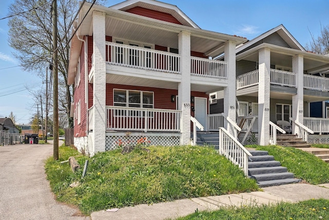 townhome / multi-family property with a porch and a balcony