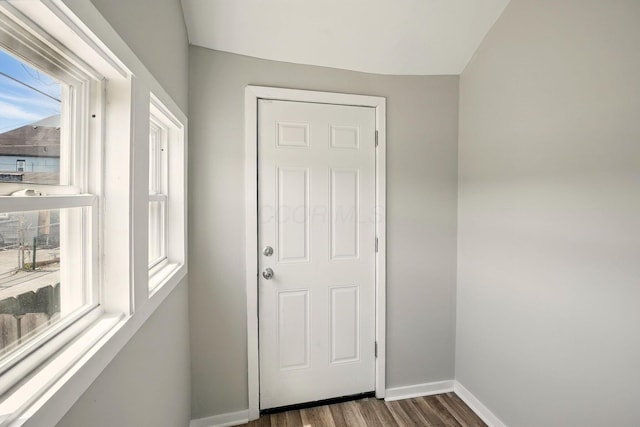 doorway featuring baseboards and dark wood-style flooring
