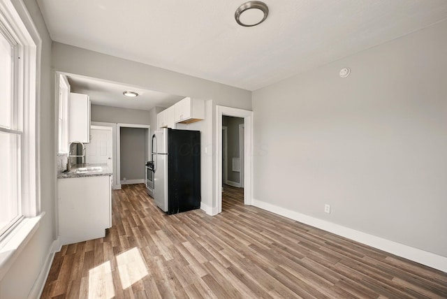 interior space featuring baseboards, wood finished floors, and a sink