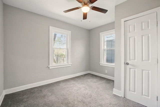 unfurnished bedroom featuring ceiling fan, baseboards, carpet flooring, and multiple windows