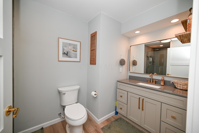 full bath with wood finished floors, toilet, a stall shower, and baseboards