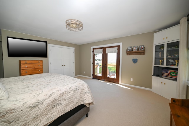 bedroom featuring a closet, access to exterior, baseboards, french doors, and light colored carpet