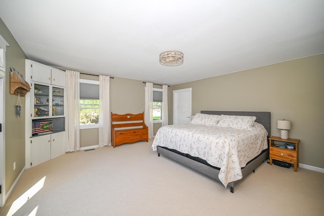 bedroom with visible vents, light carpet, and baseboards