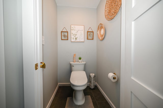 bathroom with tile patterned floors, toilet, and baseboards