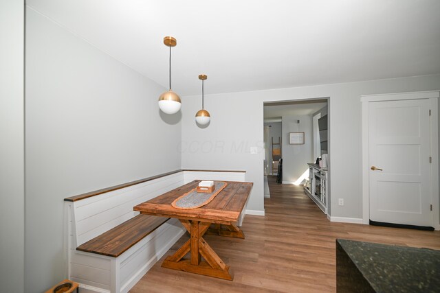 dining space featuring light wood-type flooring and baseboards