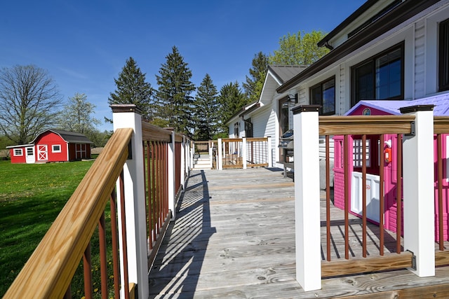 wooden terrace featuring an outdoor structure and a lawn