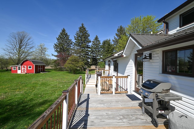 deck featuring an outdoor structure, a yard, a storage unit, and a grill