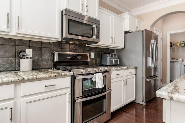 kitchen with independent washer and dryer, stainless steel appliances, decorative backsplash, crown molding, and white cabinets