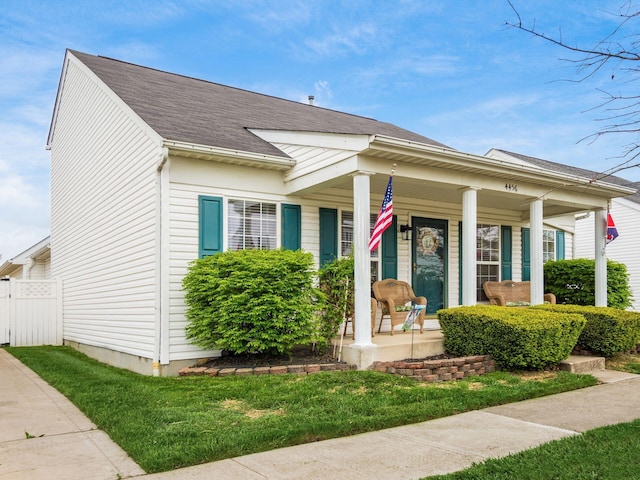 bungalow featuring covered porch, fence, and a shingled roof