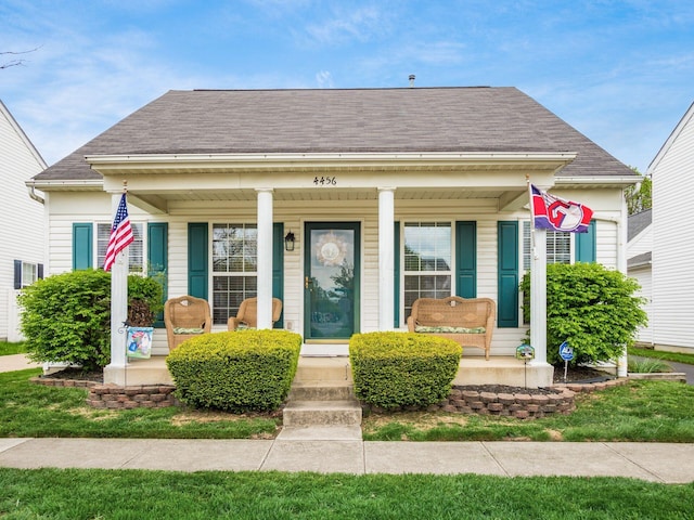 bungalow-style home with covered porch and roof with shingles