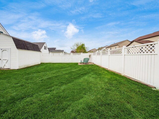 view of yard featuring an outdoor structure, a storage unit, and a fenced backyard