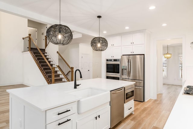 kitchen featuring recessed lighting, appliances with stainless steel finishes, light countertops, and a sink