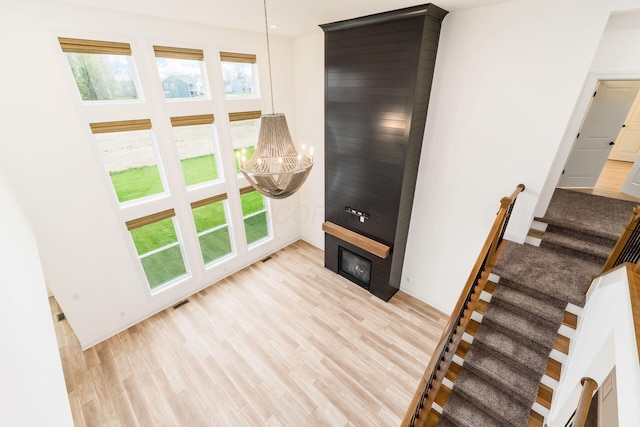 living room with stairway, light wood finished floors, and a notable chandelier