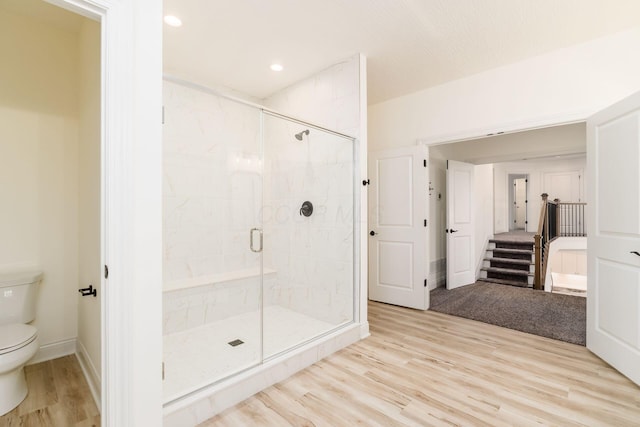 bathroom with recessed lighting, a shower stall, toilet, baseboards, and wood finished floors