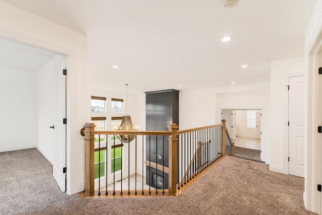 hallway with baseboards, recessed lighting, an upstairs landing, and carpet flooring