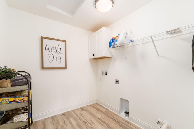 washroom featuring washer hookup, hookup for an electric dryer, gas dryer hookup, light wood-style floors, and cabinet space