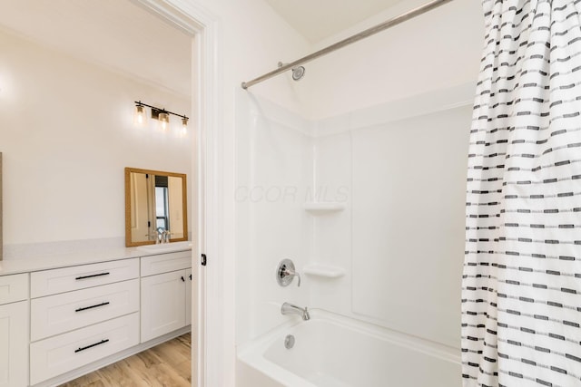 bathroom with shower / bath combo with shower curtain, wood finished floors, and vanity